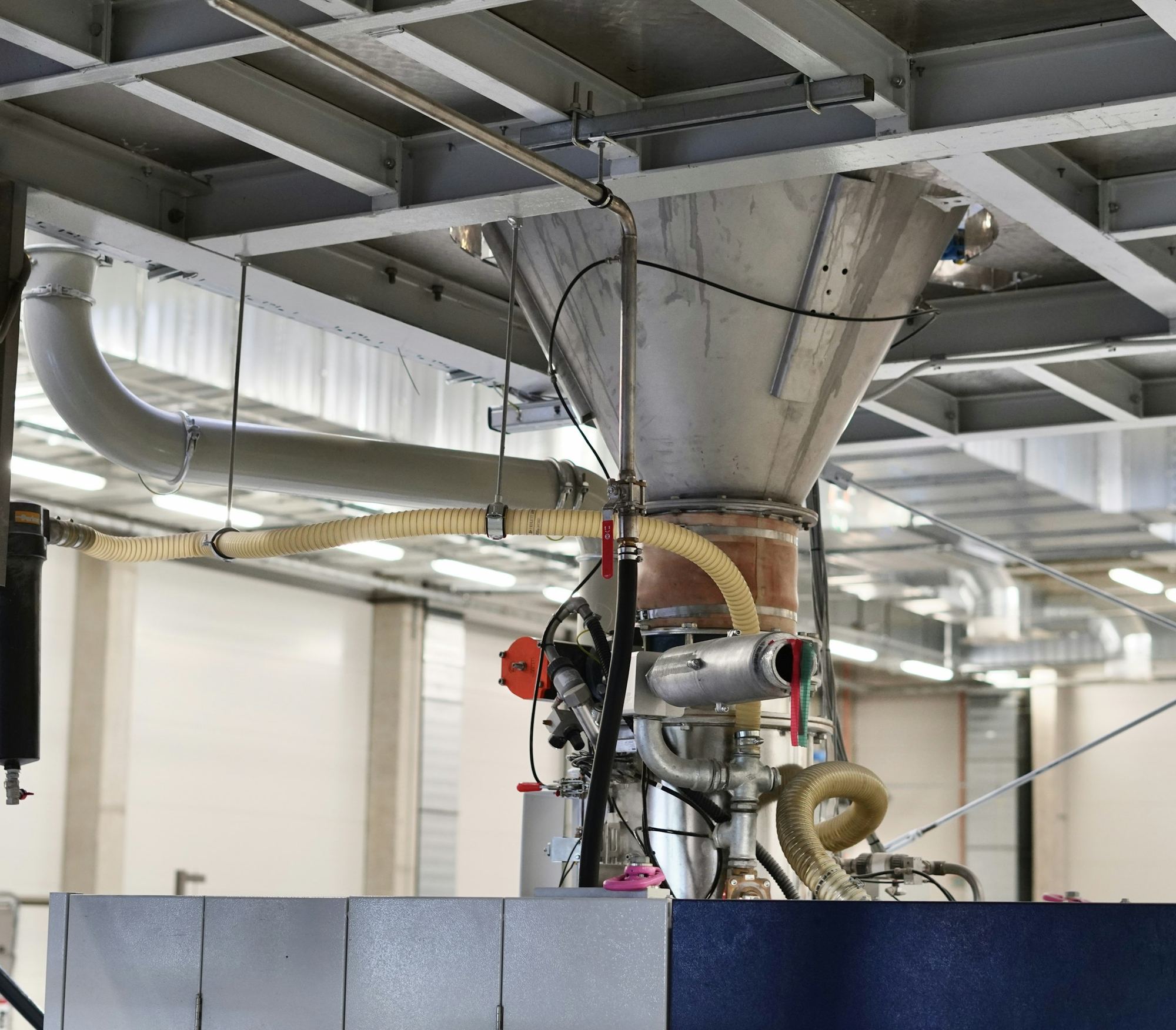 Stainless hoppers and conveying lines in a modern processing hall